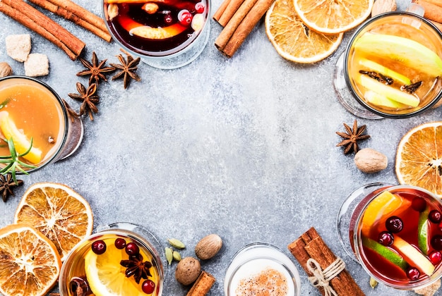 Verschillende herfst of winter seizoensgebonden alcohol warme cocktails glühwein glogg grog advocaat warme ginger ale hete beboterde rum punch glühwein op grijze achtergrond bovenaanzicht met kopie ruimte