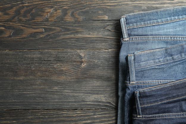 Verschillende jeans vouwen op een houten achtergrond, ruimte voor tekst