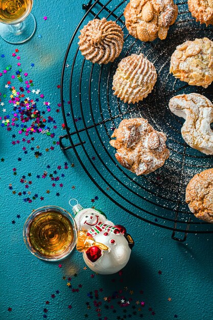 Verschillende klassieke Italiaanse zelfgemaakte amandelkoekjes met espressokoffie en glazen zoete drank op tafel Nieuwjaarskerstdecor