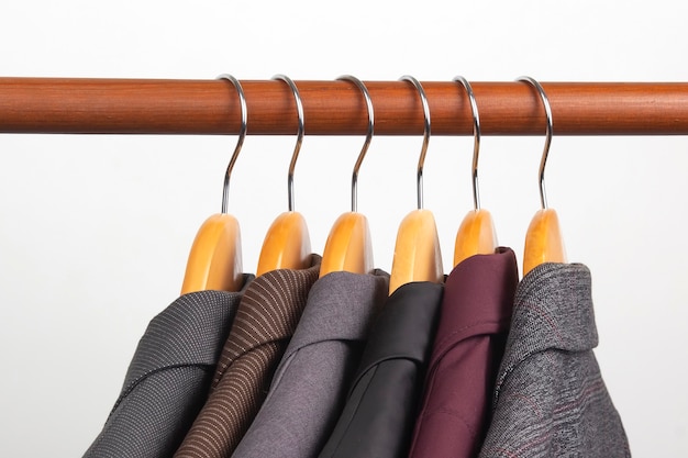 Verschillende klassieke kantoorjassen voor dames hangen aan een hanger om kleding in op te bergen. De stijlkeuze van modieuze kleding.