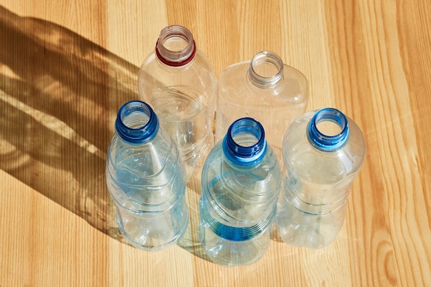 Verschillende lege plastic flessen staan op een houten ondergrond