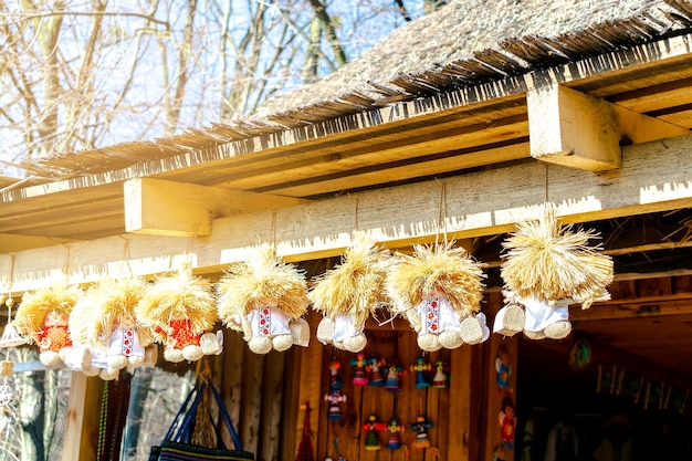 Verschillende linnen borduurwerk strofee elfinsprite poppen souvenirs op landelijke huismuur op open straat ambachtelijke markt Set antieke nationale traditionele Slavische Oekraïense handgemaakte accessoires