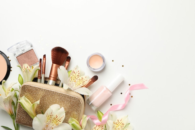 Verschillende make-up cosmetica en bloemen op een witte achtergrond