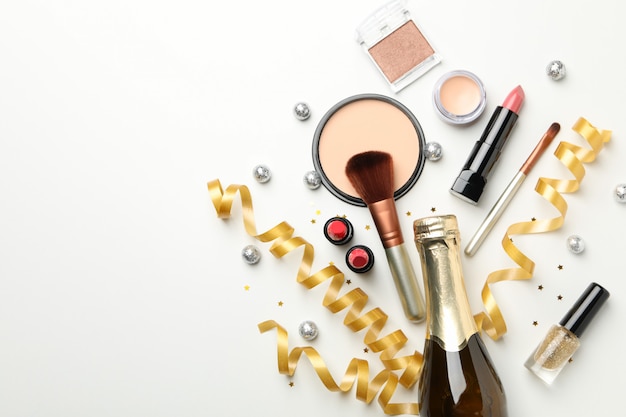 Verschillende make-up cosmetica en champagne op witte achtergrond