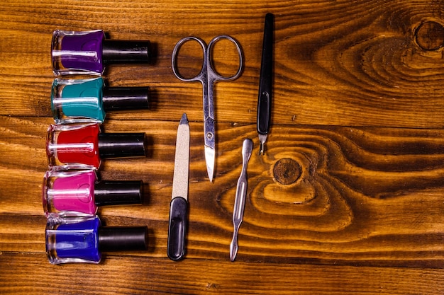 Foto verschillende manicure-gereedschappen en nagellakken op een houten tafel