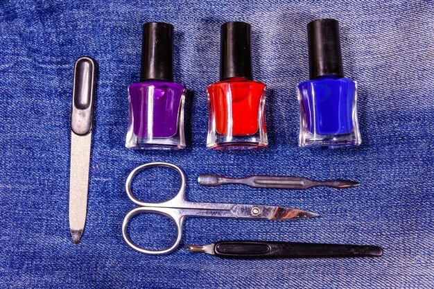 Verschillende manicure tools en nagellakken op de spijkerbroek. Bovenaanzicht