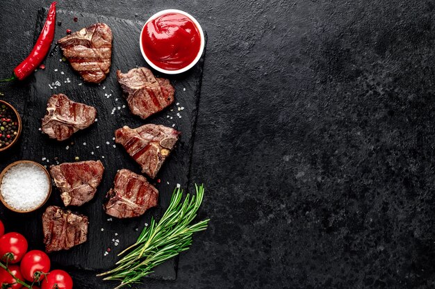 Verschillende mini-gegrilde rundvlees t-bone-steaks op stenen tafel