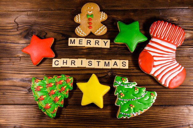 Verschillende peperkoek kerstkoekjes op rustieke houten tafel. Bovenaanzicht. Merry Christmas-inscriptie