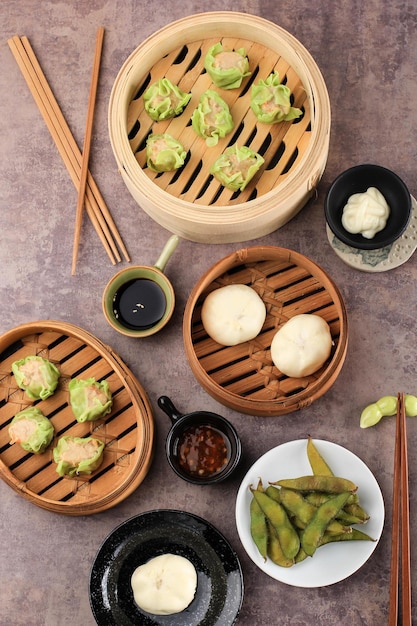 Verschillende plat lag Chinees eten, dim sum (dimsum) op bamboestoomboot boven betonnen bruine top.