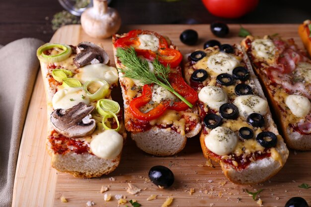 Verschillende sandwiches met groenten en kaas op snijplank op tafel close-up