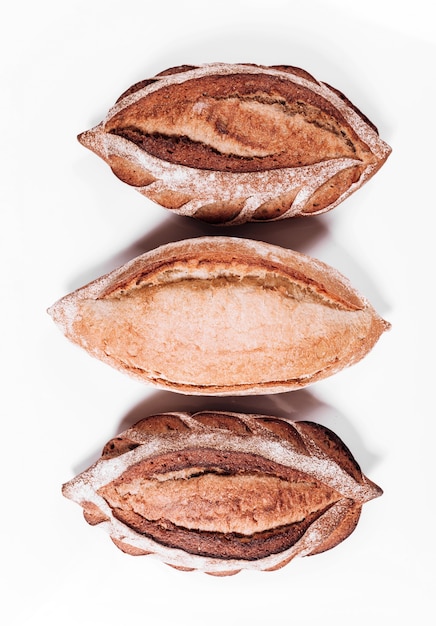 Verschillende soorten bakkerijbrood - verse rustieke knapperige broden en stokbrood op witte achtergrond.