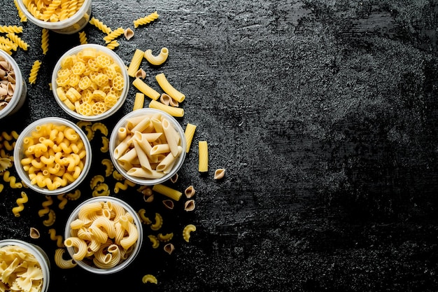 Foto verschillende soorten droge pasta in kommen