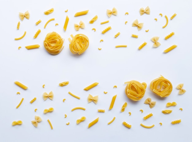 Foto verschillende soorten droge pasta op wit.