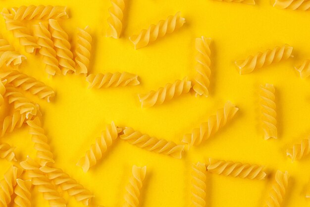 Verschillende soorten en vormen van droge italiaanse pasta op een gele close-up als achtergrond