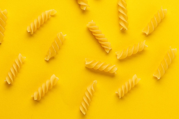 Verschillende soorten en vormen van droge italiaanse pasta op een gele close-up als achtergrond