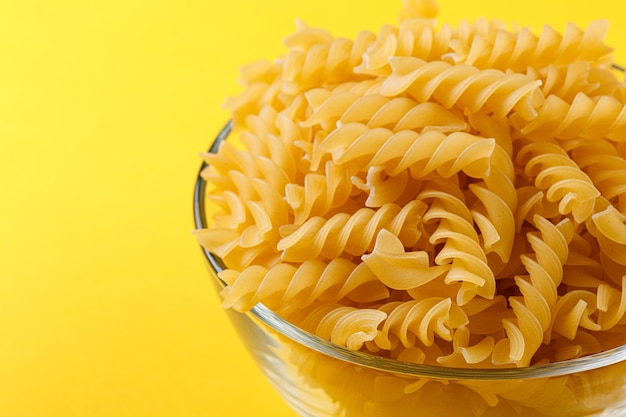 Verschillende soorten en vormen van droge italiaanse pasta op een gele close-up als achtergrond