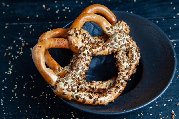 Verschillende soorten gebakken bagels met zaden op een zwarte achtergrond