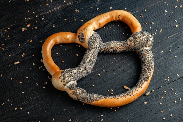 Verschillende soorten gebakken bagels met zaden op een zwarte achtergrond