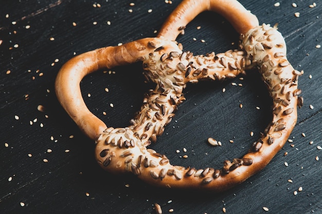 Foto verschillende soorten gebakken bagels met zaden op een zwarte achtergrond