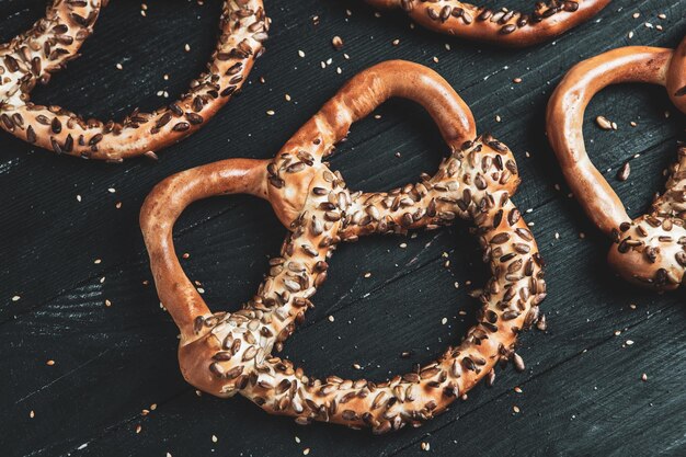 Verschillende soorten gebakken pretzels met zaden op een zwarte achtergrond