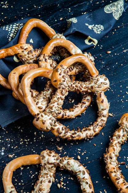 Verschillende soorten gebakken pretzels of bagels met zaden op een zwarte achtergrond