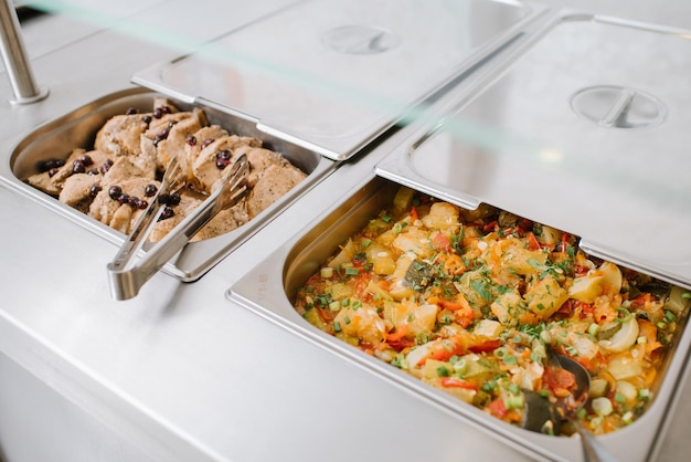 Verschillende soorten gerechten in containers op de buffettafel in het hotelrestaurant