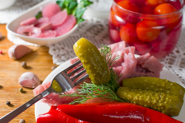 Verschillende soorten groenten in het zuur. Gepekelde komkommers, tomaat, kool, paprika, groenten, ui en knoflook geserveerd op oude stijl tafel met handgemaakte tafellaken. Zelfgemaakte gefermenteerde groenten