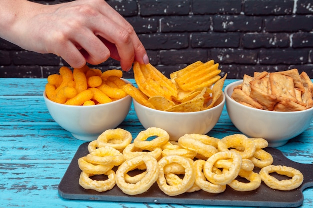 Foto verschillende soorten junkfood, zoute-sticks, zoute-crackers op houten tafel