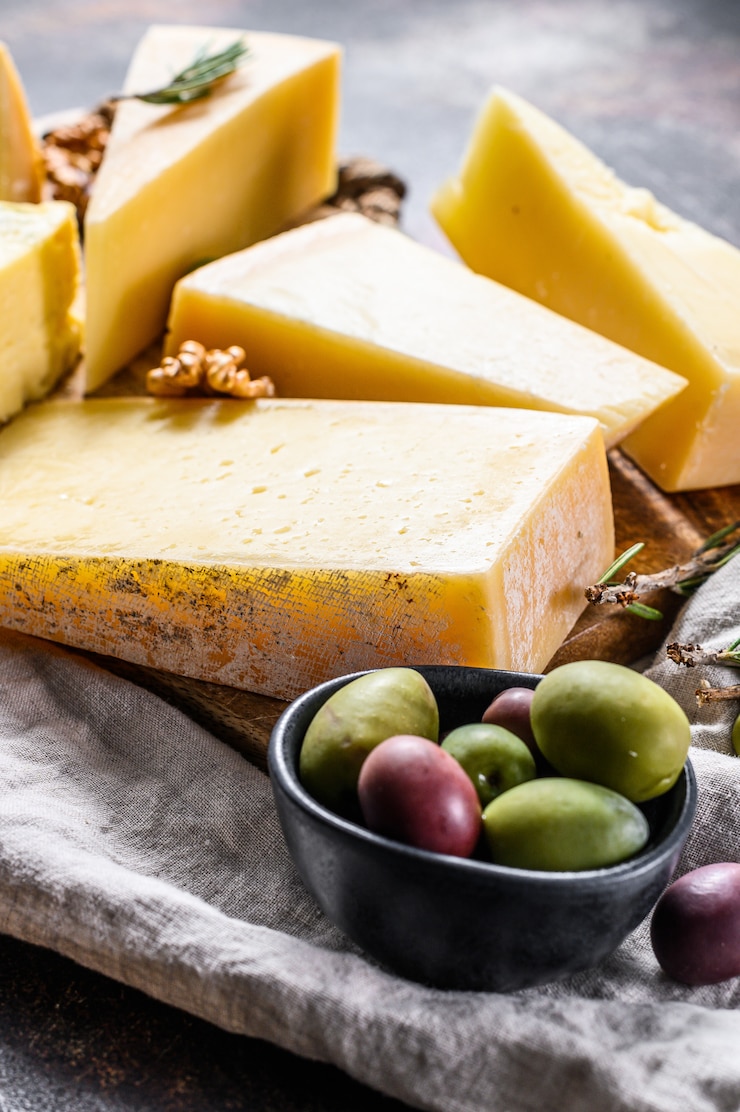 Foto verschillende soorten kaas, olijven en rozemarijn. diverse heerlijke snacks. bovenaanzicht