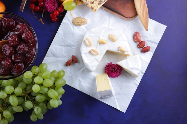 Verschillende soorten kazen met noten, bessen, fruit en honing op een blauwe achtergrond verschillende soorten kazen close-up