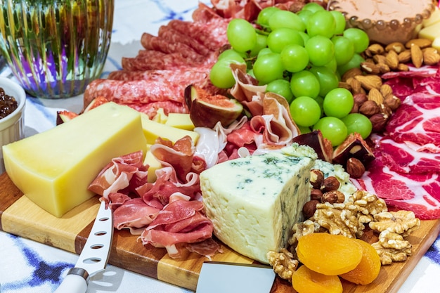 Verschillende soorten kazen, wijnen, baguettes, fruit en snacks op tafel om te proeven en vakantielandschappen.