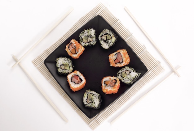 Verschillende soorten Maki-sushi op een zwarte plate.isolated op een witte achtergrond
