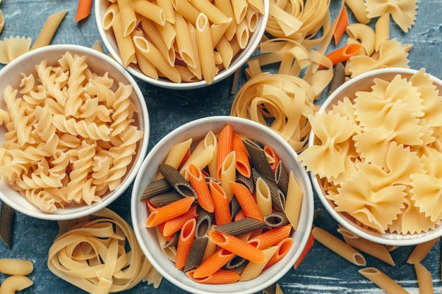 Verschillende soorten pasta in kommen op tafel.