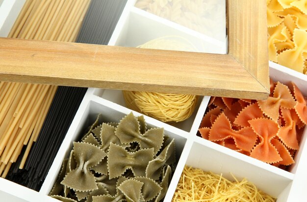 Foto verschillende soorten pasta in witte houten kist secties close-up