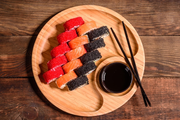 Verschillende soorten sushi geserveerd in een donker. rol met zalm, avocado, komkommer. sushi-menu. japans eten.