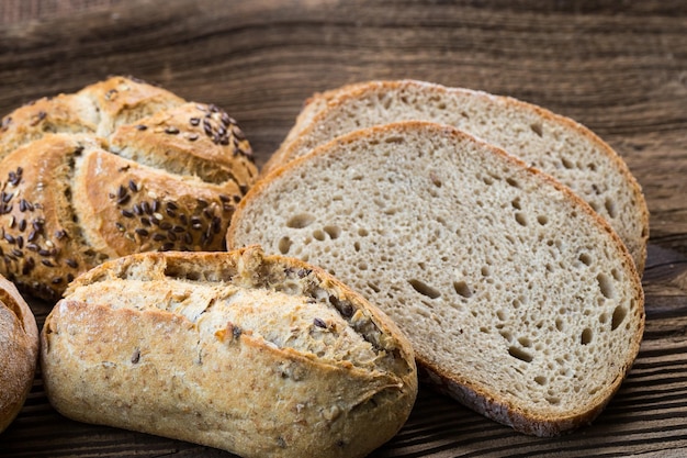 Verschillende soorten vers brood op houten tafel Geïsoleerd broodassortiment op bruine achtergrond