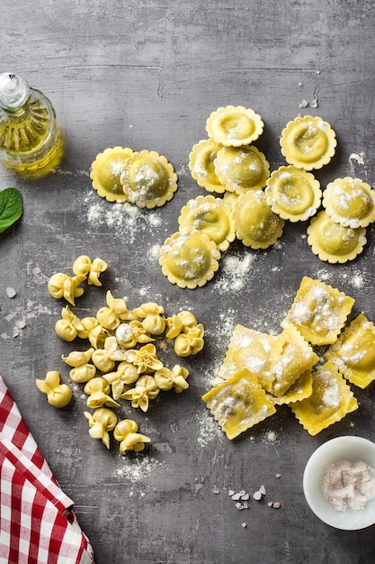 Verschillende soorten verse rauwe italiaanse ravioli op tafel met kookingrediënten thuiskeuken