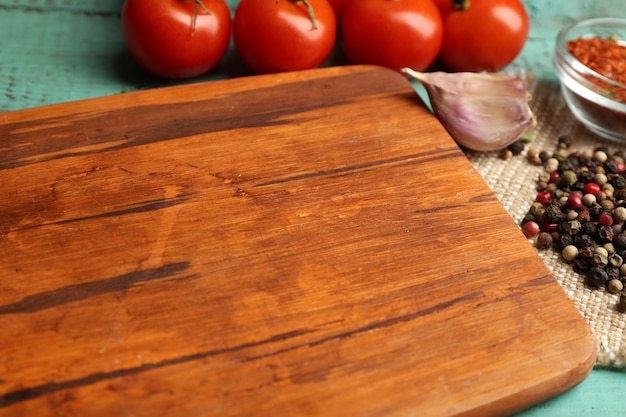 Verschillende specerijen en kruiden met snijplank op een houten tafel achtergrondkleur