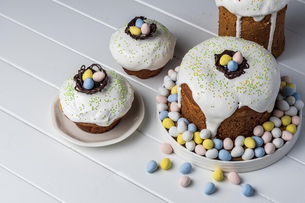 Verschillende traditionele paascakes en snoepeieren op een witte achtergrond, versierd met zelfgemaakte gebakjes bovenaanzicht