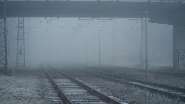 Verschillende treinrails eindigend in mist, spoorlijnen tijdens een koude herfstochtend