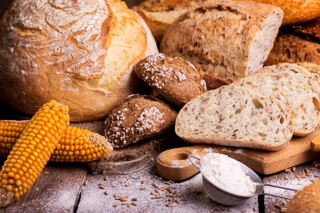 Verschillende vers brood en broodjes op de houten tafel