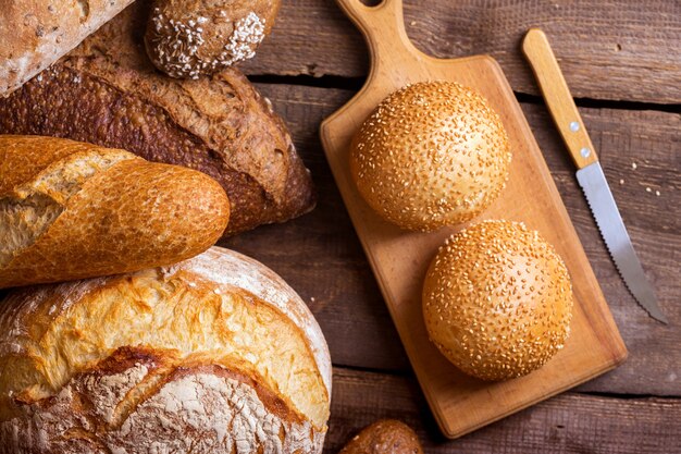 Verschillende vers brood en broodjes op de houten tafel