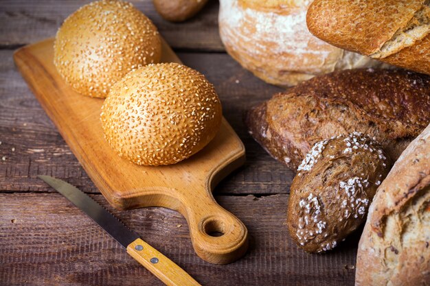 Verschillende vers brood en broodjes op de houten tafel