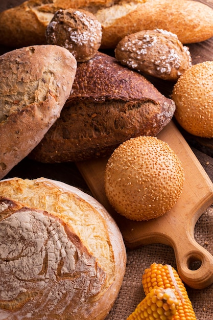 Verschillende vers brood en broodjes op de houten tafel