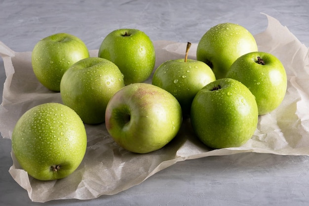 Verschillende verse rijpe groene appels liggen op perkamentpapier