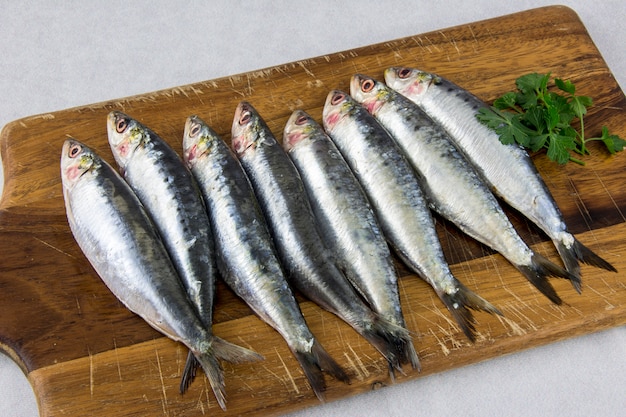 Verschillende verse sardines op een houten bord