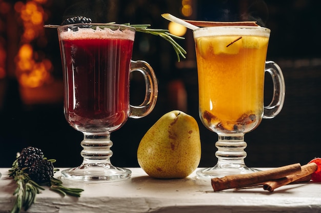 Verschillende verwarmende kleurrijke fruitthee of cocktails in een glazen mokken Glühwein grog hete grog punch