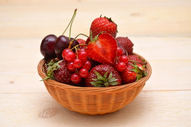 Verschillende zomerbessen in een mand aardbeien kersen en rode aalbessen