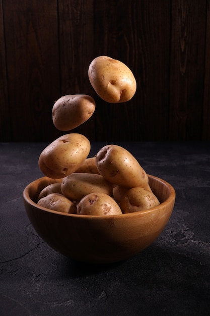 Verse aardappelen die boven de houten kom stijgen