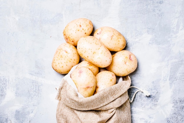 Verse aardappelen in een canvas tas voedsel achtergrond bovenaanzicht